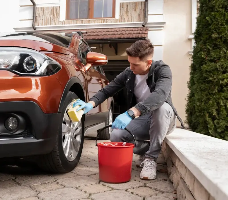 Lavage auto à domicile Le Mesnil-Théribus : professionnel intervenant sur un véhicule